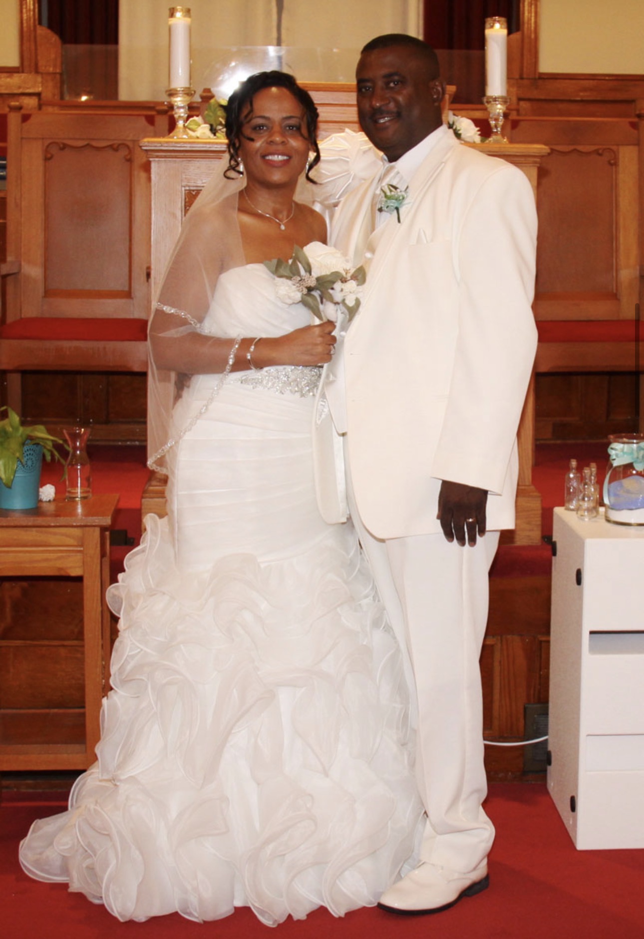 Bride and groom in ivory standing together at the church altar after their ceremony